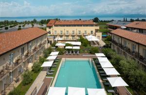 z widokiem na ośrodek z basenem i parasolami w obiekcie Leonardo Hotel Lago di Garda - Wellness and Spa w mieście Lazise