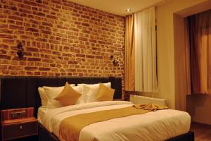 ein Schlafzimmer mit einem großen Bett mit Ziegelwand in der Unterkunft Galata Calm Tale Hotel in Istanbul