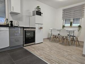 a kitchen with white appliances and a table and chairs at Villa DIAL Lohovo-dvoslap in Bihać
