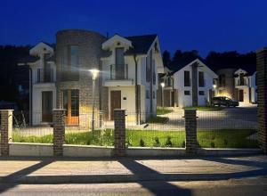 a house with a fence in front of it at night at Royal Villa - HAWAII in Vrnjačka Banja