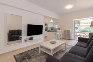 a living room with a tv and a couch and a table at Great Two Bedrooms Apartment in Varkiza in Vari