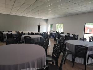 Cette chambre est dotée de tables et de chaises ainsi que de linge de maison blanc. dans l'établissement Green Forest Resort, à Setiu