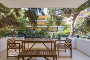 a table and chairs on a patio with trees at Great Two Bedrooms Apartment in Varkiza in Vari