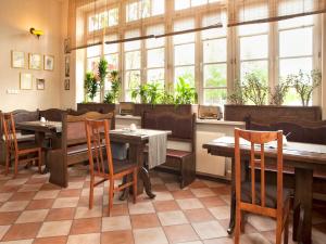 a restaurant with tables and chairs and windows at Pensjonat Zacisze in Plewiska