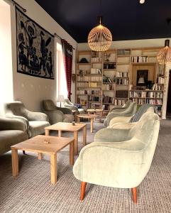 a living room with couches and tables and bookshelves at hôtel oberland in Le Bourg-dʼOisans