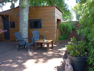 a patio with two chairs and a table and a house at Tiny House plein centre in Hourtin
