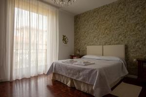 卡利亚里德布尼卡蒂维酒店的一间卧室，里面有一张床和一扇大窗户。