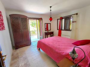 Un dormitorio con una cama con una colcha roja. en Mulberry House, en Kas