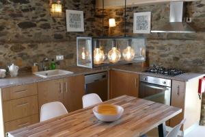 une cuisine avec une table en bois et un comptoir en bois dans l'établissement Casa Escola Velha, à Vale de Cameiro