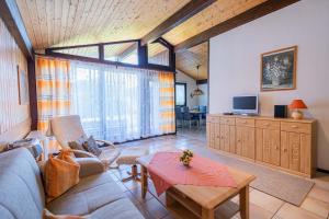 un soggiorno con un divano e un tavolo di Ferienwohnpark Immenstaad am Bodensee Satteldachhaus Typ 9 SD 57 a Immenstaad am Bodensee