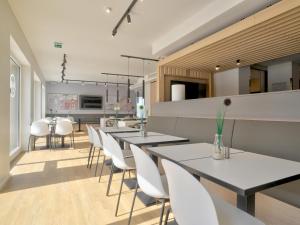 een eetkamer met witte tafels en witte stoelen bij B&B HOTEL Bielefeld-City in Bielefeld