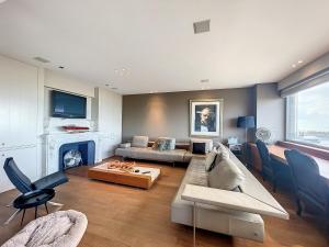 ein Wohnzimmer mit Couch und Kamin in der Unterkunft Apartment Long Beach with sauna and garage in Middelkerke