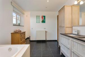 La grande salle de bains est pourvue d'un lavabo et d'une baignoire. dans l'établissement Hoeve t' Korenhof - Koksijde, à Coxyde 21 autres photos