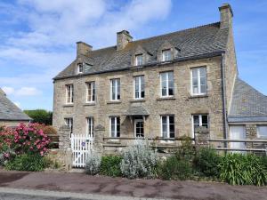 Omonville-la-RogueGITE DU HABLE的白色围栏的古老石屋