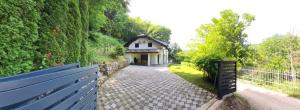 a house with a fence in front of a driveway at Villa DIAL Lohovo-dvoslap in Bihać