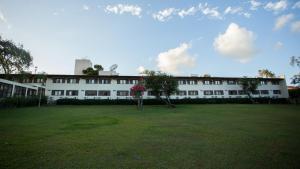 a large white building with a large grass yard at Hotel Fazenda Portal de Gravatá in Gravatá