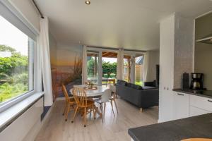 Una cocina y una sala de estar con mesa y sillas. en Welcome in - Vakantiewoning - Horizon 14 - Renesse, en Renesse