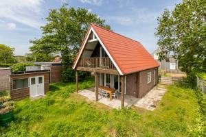 una pequeña casa con techo naranja en Welcome in - Vakantiewoning - Horizon 14 - Renesse, en Renesse