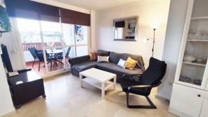 a living room with a couch and a table at 2BDR Sunny apartment with pool and private parking in Benalmádena in Benalmádena