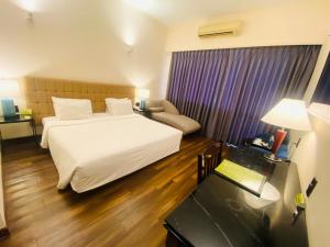 a hotel room with a white bed and a desk at Liberty 2 Hotel in Ho Chi Minh City