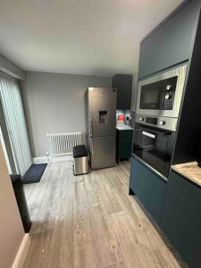 a kitchen with a stainless steel refrigerator in a room at Quaint cottage close to Marina in Pembrokeshire