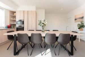 une cuisine avec une table et six chaises dans l'établissement Villa Petit Mouche - Recently renovated villa close to beach, à Coxyde