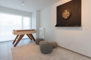 une chambre avec une table et un jeu de fléchettes sur le mur dans l'établissement Villa Petit Mouche - Recently renovated villa close to beach, à Coxyde
