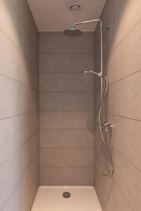 une douche avec pommeau de douche dans une salle de bain dans l'établissement Villa Petit Mouche - Recently renovated villa close to beach, à Coxyde 17 autres photos