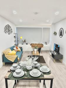 a living room with a table with plates on it at Convenient Contractor & Family Stay - 5 Guests, Pets Welcome, Parking Included! in Bracknell