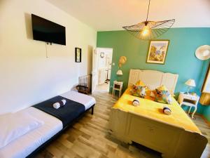 1 dormitorio con 2 camas y TV de pantalla plana en Auberge du relais d auniac Hotel Bar Restaurant Piscine, en Anglars-Nozac