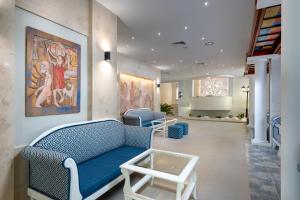 una sala de espera con un sofá azul y una pintura en Sentido Bellevue Beach- All Inclusive & Beach Access, en Sunny Beach