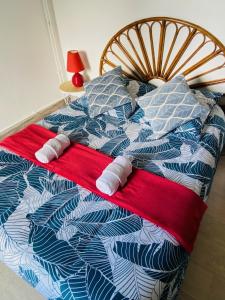 1 cama con 2 almohadas y manta roja en Auberge du relais d auniac Hotel Bar Restaurant Piscine en Anglars-Nozac