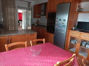 una cucina con tavolo e tovaglia rosa a pois di Chalet con gran jardin y piscina privada a Peñíscola Altre 7 foto