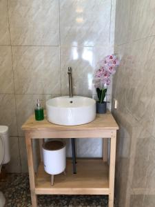 a bathroom with a sink and flowers on a table at Yohana Cottage in Tual
