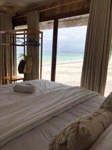 a bedroom with a bed with a view of the beach at Yohana Cottage in Tual