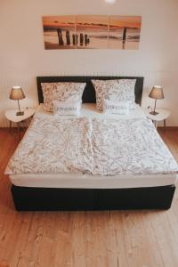a large bed in a bedroom with two tables at Ferienwohnung Nr 3 in Hinrichsdorf