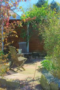 a patio with two chairs and a pergola with flowers at Ferienwohnung Nr 3 in Hinrichsdorf +6 photos