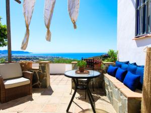 a patio with a table and chairs and the ocean at Holiday Home Camelia Blanca by Interhome in Torrox
