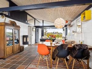 a dining room with orange chairs and a table at Holiday Home Malena - 175m from the sea by Interhome in Allingåbro