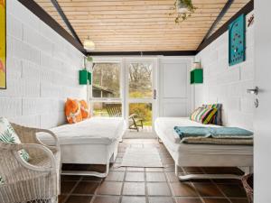 a room with two beds and a window at Holiday Home Malena - 175m from the sea by Interhome in Allingåbro