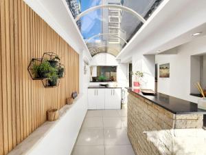 una cucina con armadietti bianchi e un bancone nero di Urban Style House with Jacuzzi & Garage a Città del Capo