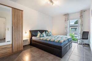 a bedroom with a bed and a desk and a window at Ferienvilla Kapitänshaus in Ostseebad Karlshagen