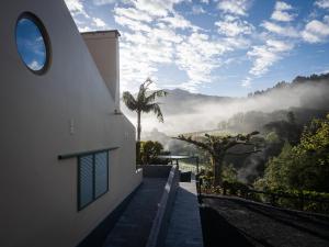 a building with a window and a view of the mountains at Casa nas Caldeiras in Furnas