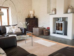 a living room with a couch and a fireplace at Holiday Home Rivers Reach by Interhome in Bere Alston +27 photos
