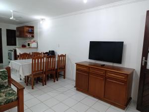 uma sala de estar com uma televisão e uma mesa de jantar em Casa Duplex 3 suítes em Condomínio Fechado em Porto Seguro