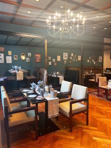 uma sala de jantar com uma mesa e cadeiras e um lustre em Vintagehotel Adler em Bad Bertrich