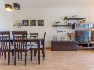 a dining room with a table and chairs and a tv at Apartment Viena 13 by Interhome in L'Ampolla