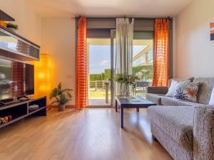 a living room with a couch and a tv at Apartment Viena 13 by Interhome in L'Ampolla