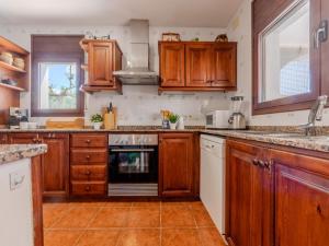 Una cocina con gabinetes de madera y un horno de estufa. en Villa Alicia by Interhome, en L'Ampolla