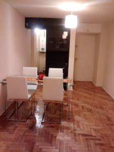 comedor con mesa de cristal y sillas blancas en Nueva Córdoba Temporario en Córdoba